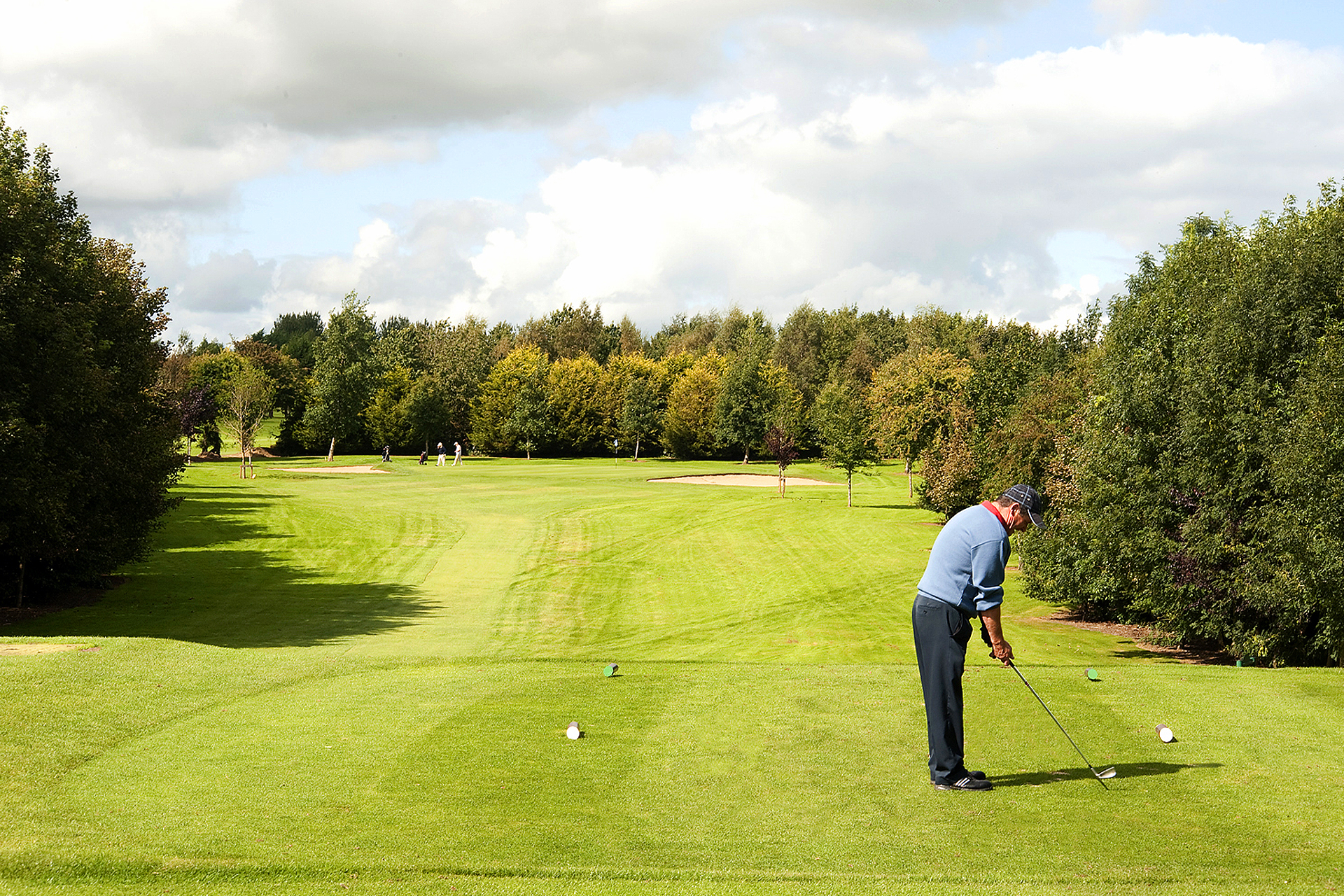Golfer taking a swing on golf course 
